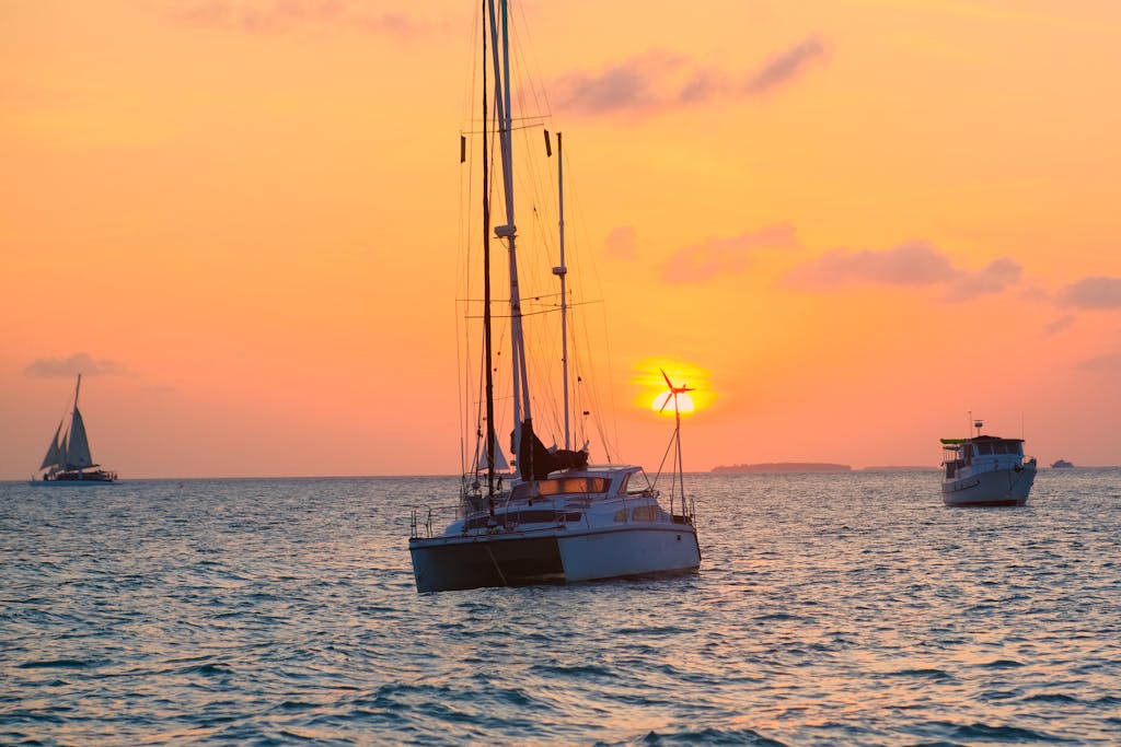 A sailboat is in the ocean at sunset