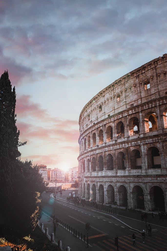 Scenic view of the iconic Colosseum in Rome at sunset, showcasing ancient architecture.