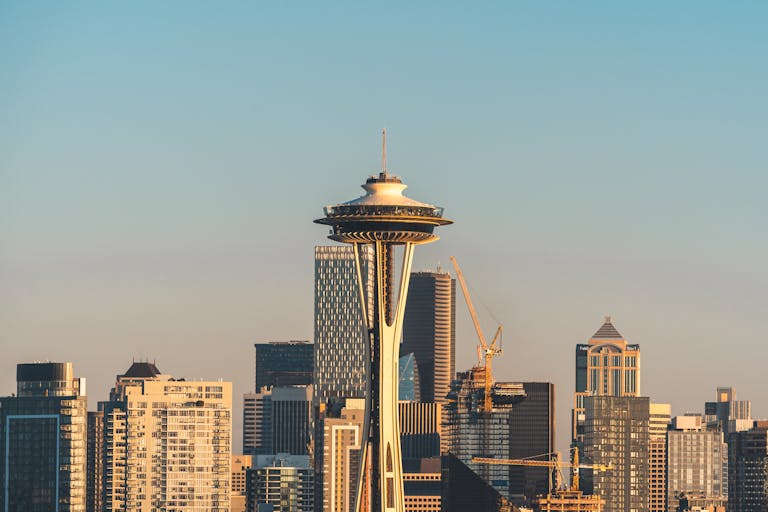 Iconic Space Needle amidst skyscrapers in Seattle during sunset, showcasing urban architecture and cityscape beauty.