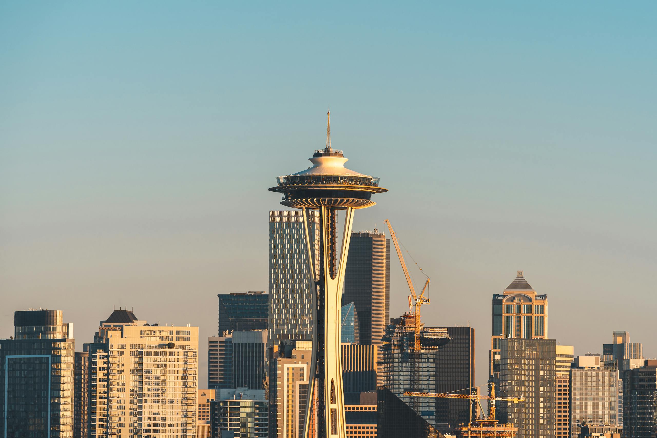 Iconic Space Needle amidst skyscrapers in Seattle during sunset, showcasing urban architecture and cityscape beauty.